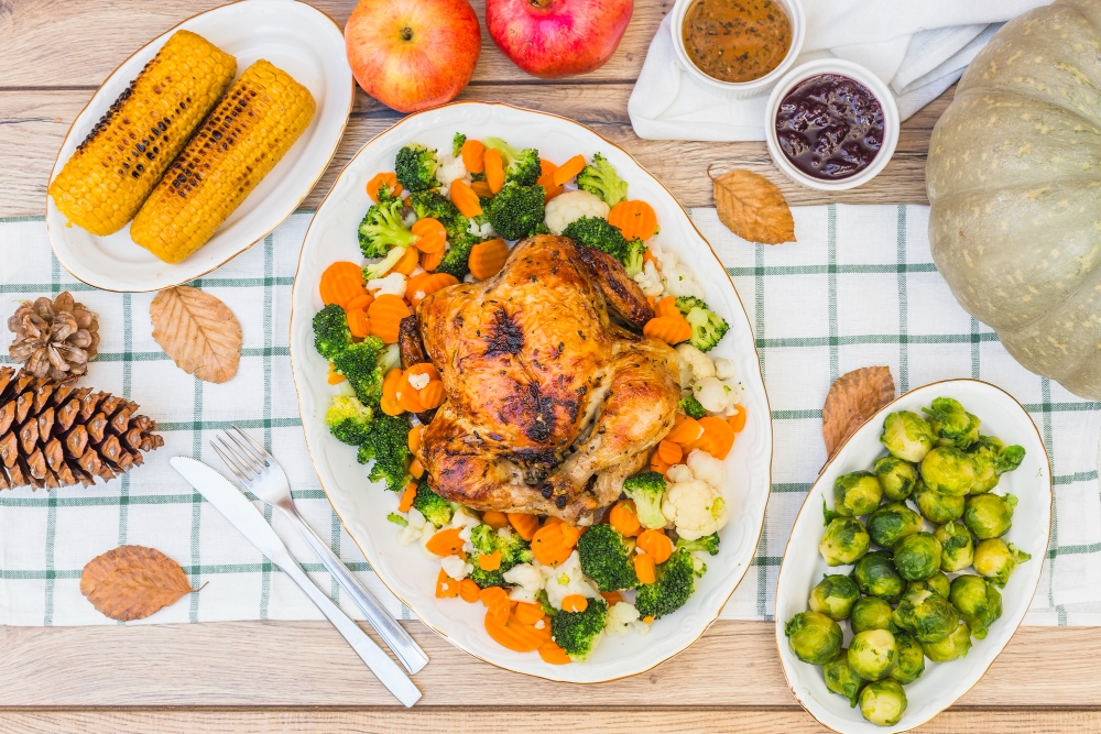 Overhead shot of a sheet pan dinner featuring roasted chicken, Brussels sprouts, and potatoes garnished with fresh herbs and lemon wedges.