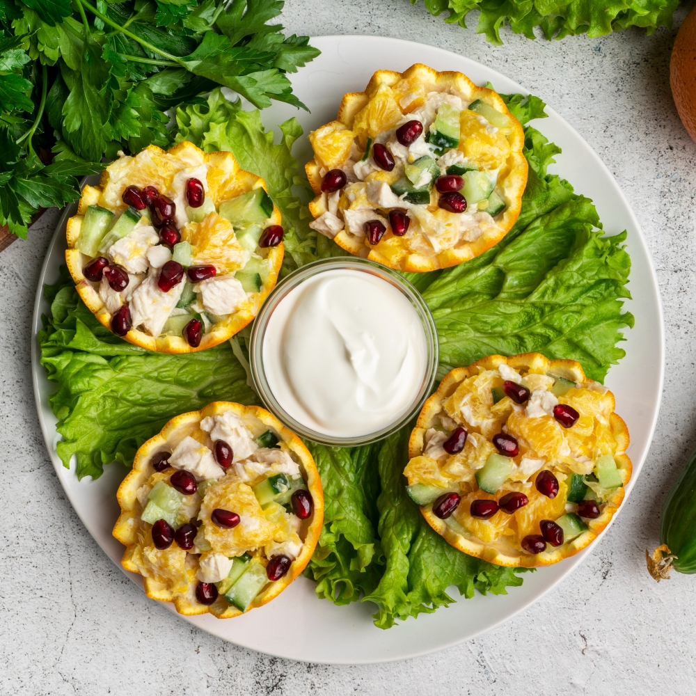 "Vibrant plate featuring healthy cottage cheese cups with diced cucumber, orange segments, pomegranate seeds, and a creamy yogurt dip."