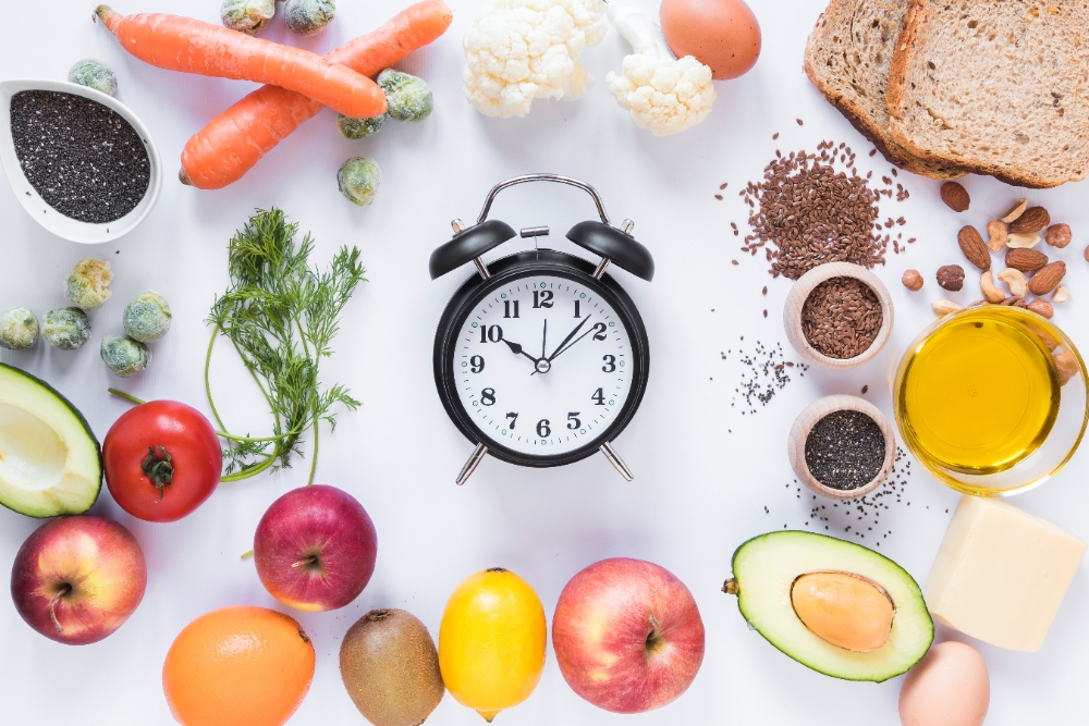 An assortment of fresh vegetables, fruits, grains, and cooking essentials arranged around a clock, symbolizing 30-minute meal prep.