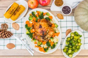 easy dinner ideas: Overhead shot of a sheet pan dinner featuring roasted chicken, Brussels sprouts, and potatoes garnished with fresh herbs and lemon wedges.