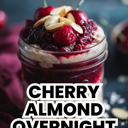 Mason jar of cherry almond overnight oats topped with fresh cherries and almonds